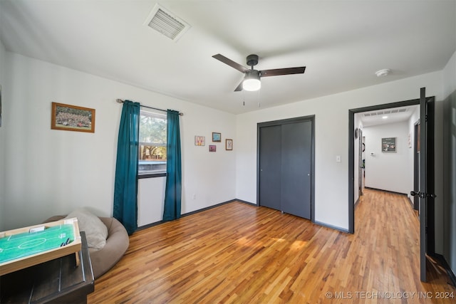 bedroom featuring light wood-type flooring, ceiling fan, and a closet