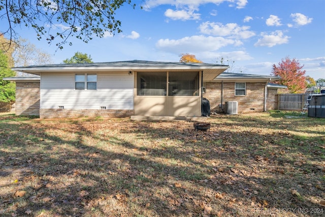 rear view of property featuring a sunroom, central AC unit, and a lawn