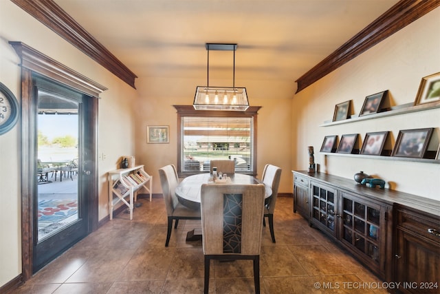 dining space featuring ornamental molding and dark tile patterned floors