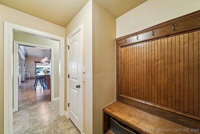 mudroom featuring ornamental molding and light tile patterned flooring