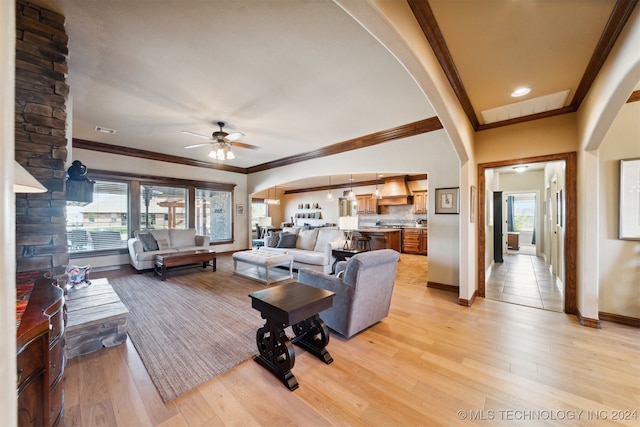 living room featuring ornamental molding, ceiling fan, and light hardwood / wood-style flooring