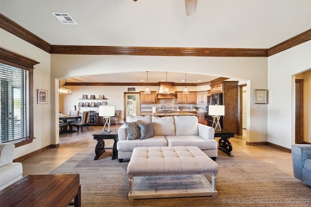 living room with sink, light hardwood / wood-style flooring, ceiling fan, and ornamental molding