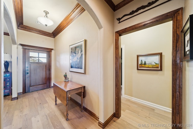 foyer with light wood-type flooring and ornamental molding