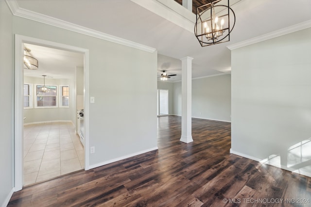 unfurnished room with decorative columns, crown molding, and wood-type flooring