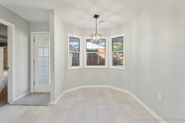 unfurnished dining area with a chandelier