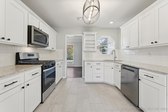 kitchen with decorative light fixtures, stainless steel appliances, white cabinetry, and sink