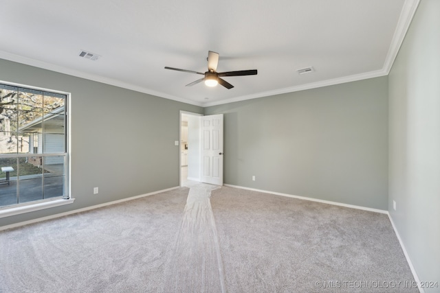 carpeted empty room featuring ceiling fan and crown molding