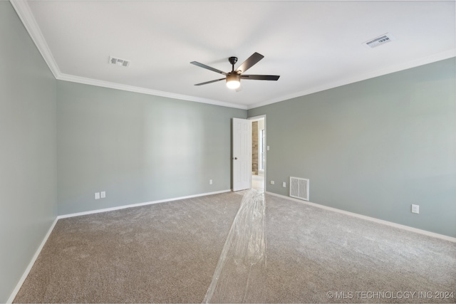 spare room featuring light colored carpet, ceiling fan, and ornamental molding