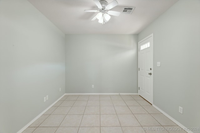 tiled spare room with ceiling fan