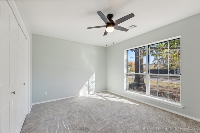 spare room featuring ceiling fan and light colored carpet