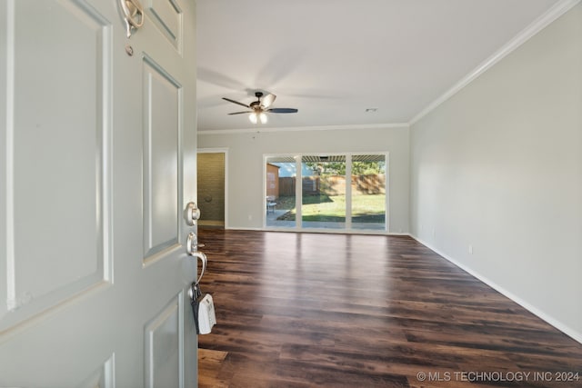 empty room featuring crown molding, ceiling fan, and dark wood-type flooring