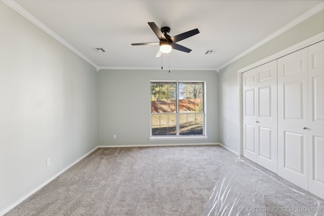 unfurnished bedroom with ceiling fan, crown molding, and light carpet