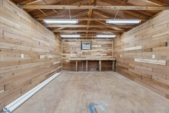 misc room featuring wooden walls and lofted ceiling