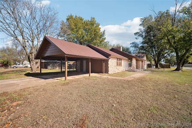 view of side of home with a carport and a lawn