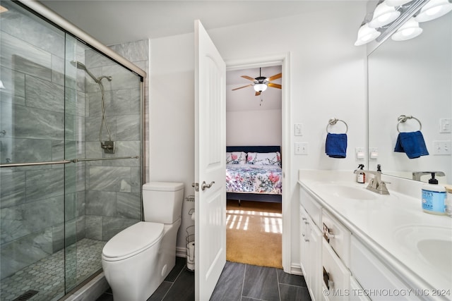 bathroom with vanity, ceiling fan, toilet, and a shower with shower door