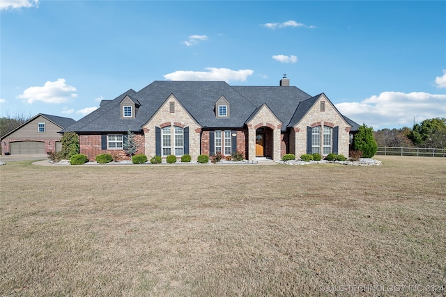 french country style house with a garage and a front yard