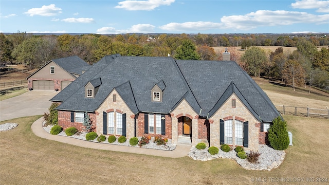 french provincial home featuring a front lawn and a garage