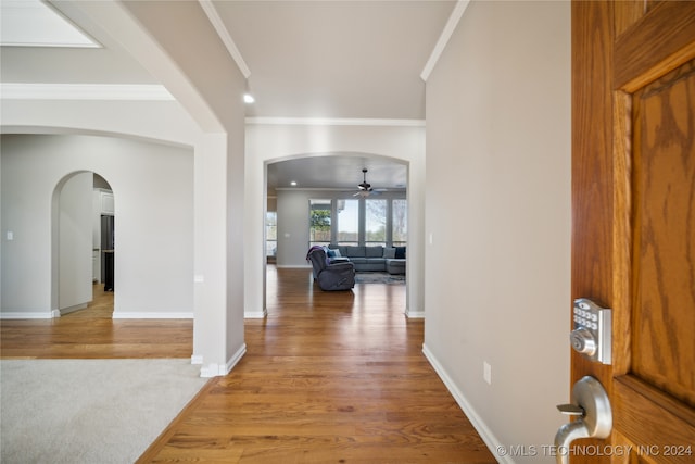 entrance foyer featuring ornamental molding, light wood-type flooring, and ceiling fan