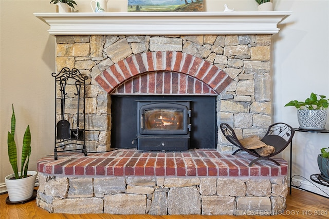 room details with a wood stove and hardwood / wood-style flooring