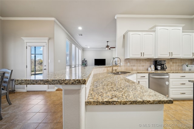 kitchen featuring dishwasher, kitchen peninsula, white cabinets, sink, and backsplash