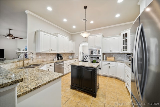 kitchen featuring a center island, white cabinets, sink, appliances with stainless steel finishes, and decorative light fixtures