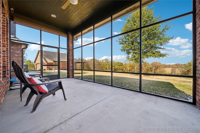 unfurnished sunroom featuring ceiling fan