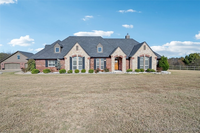 french provincial home with a garage and a front lawn