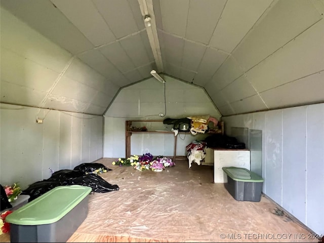 interior space featuring vaulted ceiling and concrete floors