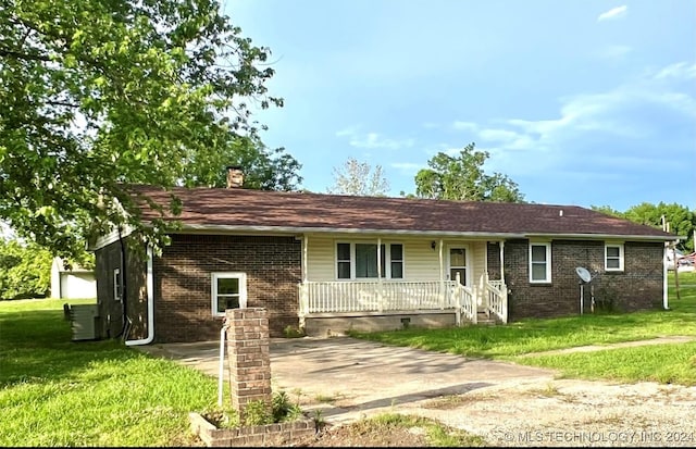 single story home featuring central AC unit, covered porch, and a front lawn