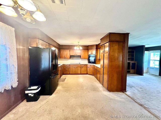 kitchen with black appliances, light carpet, decorative light fixtures, and an inviting chandelier