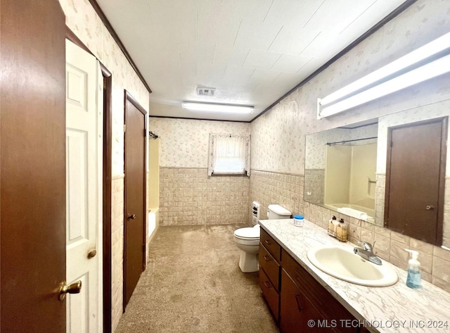 bathroom with a bathtub, vanity, and toilet