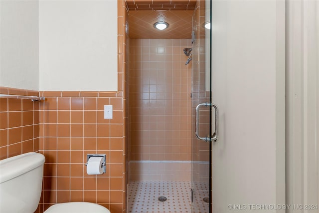 3920 S Utica Ave, Tulsa, OK 74105 - bathroom featuring a stall shower, toilet, and tile walls
