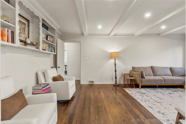 living room featuring dark wood-type flooring, beamed ceiling, and ornamental molding