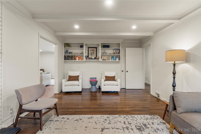 sitting room featuring dark wood-type flooring, beam ceiling, and ornamental molding