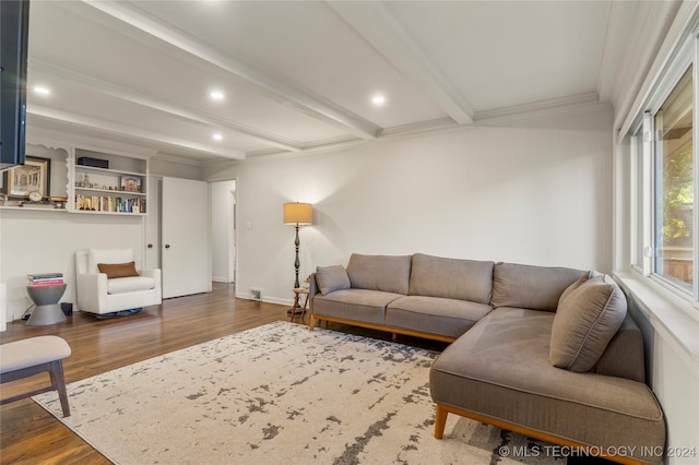 living room featuring beamed ceiling, wood-type flooring, and ornamental molding