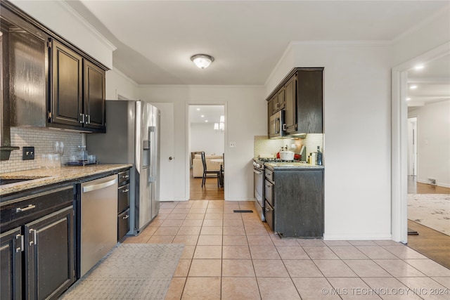 kitchen featuring light stone counters, crown molding, appliances with stainless steel finishes, dark brown cabinetry, and light hardwood / wood-style floors