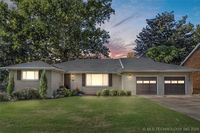 view of front of home featuring a garage and a yard