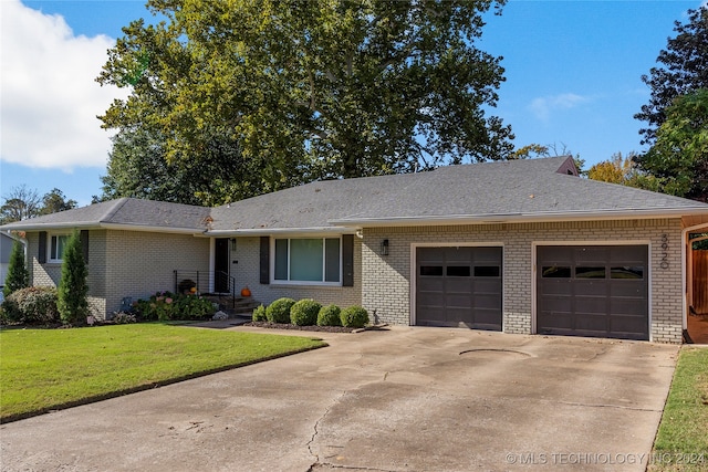 ranch-style home featuring a garage and a front lawn