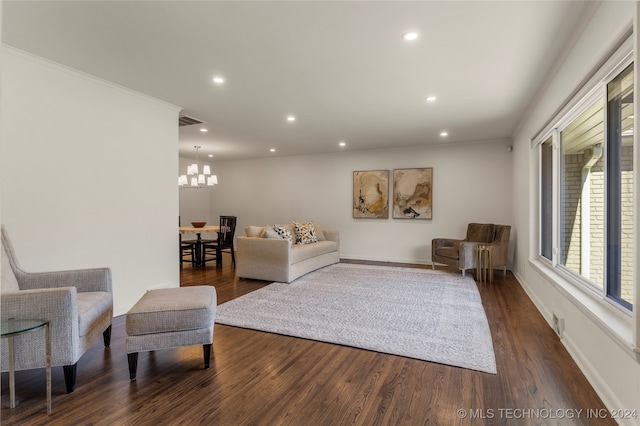 living room with ornamental molding, a notable chandelier, and dark hardwood / wood-style floors