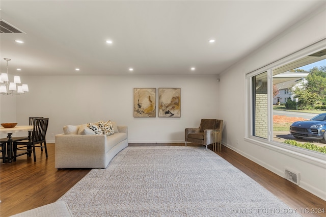 living room featuring an inviting chandelier and dark hardwood / wood-style flooring