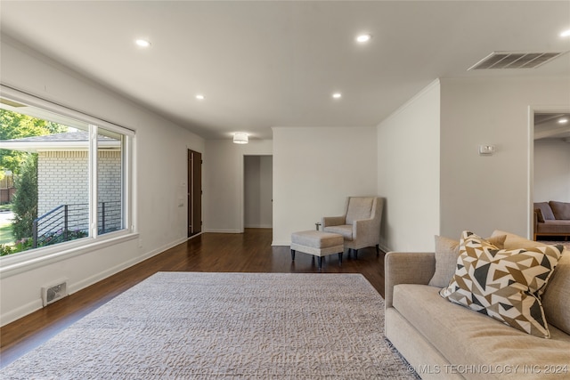 living area with ornamental molding and dark hardwood / wood-style flooring