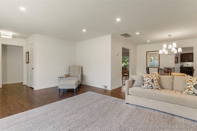 living room with ornamental molding, a chandelier, and dark hardwood / wood-style floors