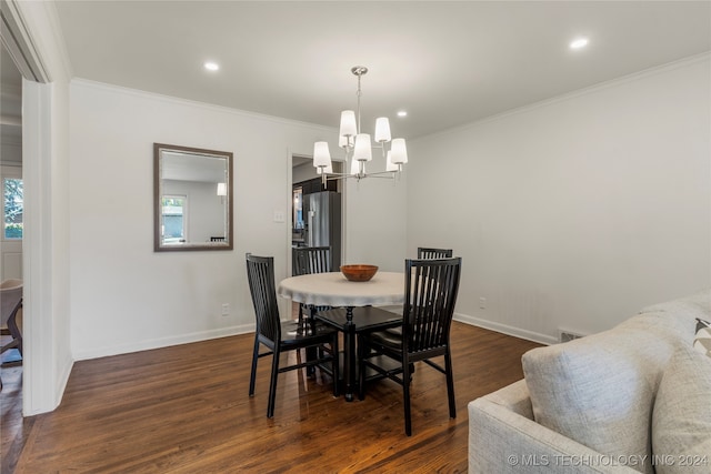 dining area with dark hardwood / wood-style floors, a chandelier, and ornamental molding