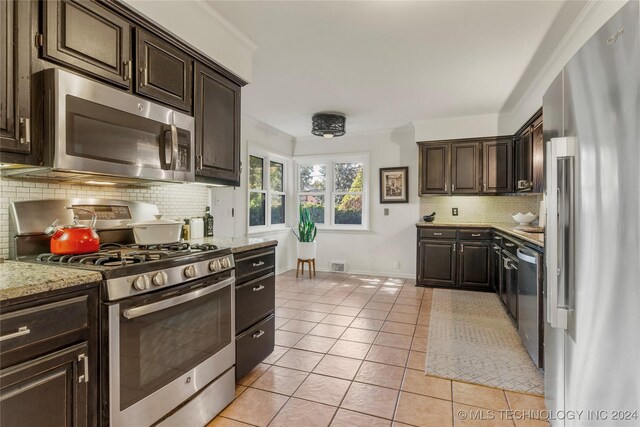 3920 S Utica Ave, Tulsa, OK 74105 - kitchen featuring appliances with stainless steel finishes, backsplash, dark brown cabinetry, light tile patterned floors, and light stone counters