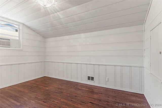3920 S Utica Ave, Tulsa, OK 74105 - empty room with lofted ceiling, dark wood-style floors, a decorative wall, and cooling unit