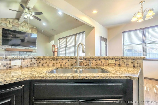 interior space with plenty of natural light, vaulted ceiling with beams, tasteful backsplash, and sink