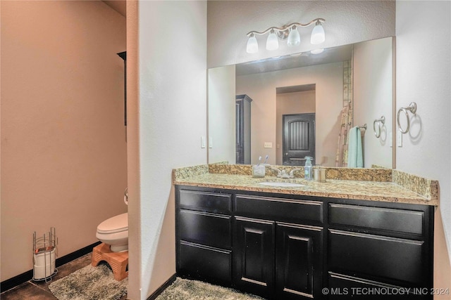 bathroom featuring tile patterned floors, toilet, and vanity