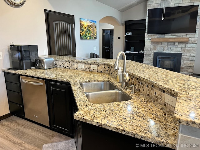 kitchen featuring light hardwood / wood-style floors, light stone counters, backsplash, and sink