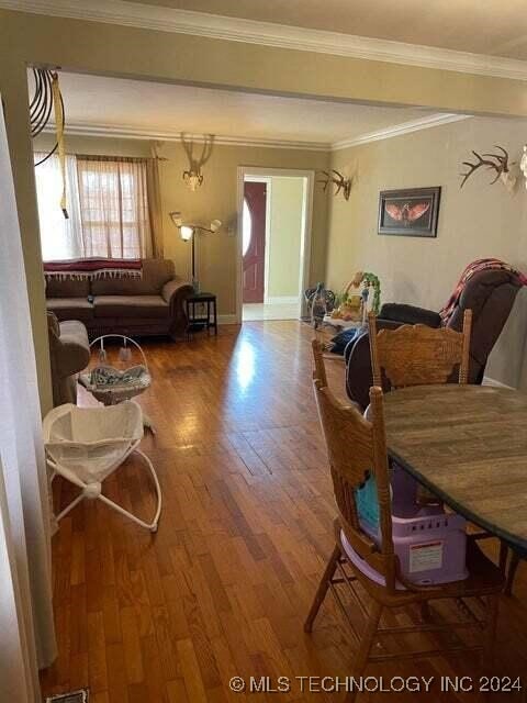 living room featuring hardwood / wood-style flooring and crown molding