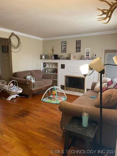 living room featuring hardwood / wood-style floors and ornamental molding